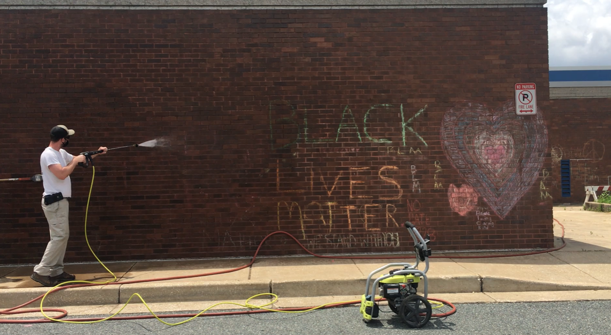 Workers removing chalk drawings on an elementary school in Maryland