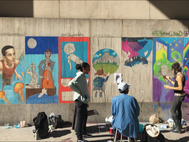 Students painting posters on Fashion Institute of Technology Seventh Avenue wall.